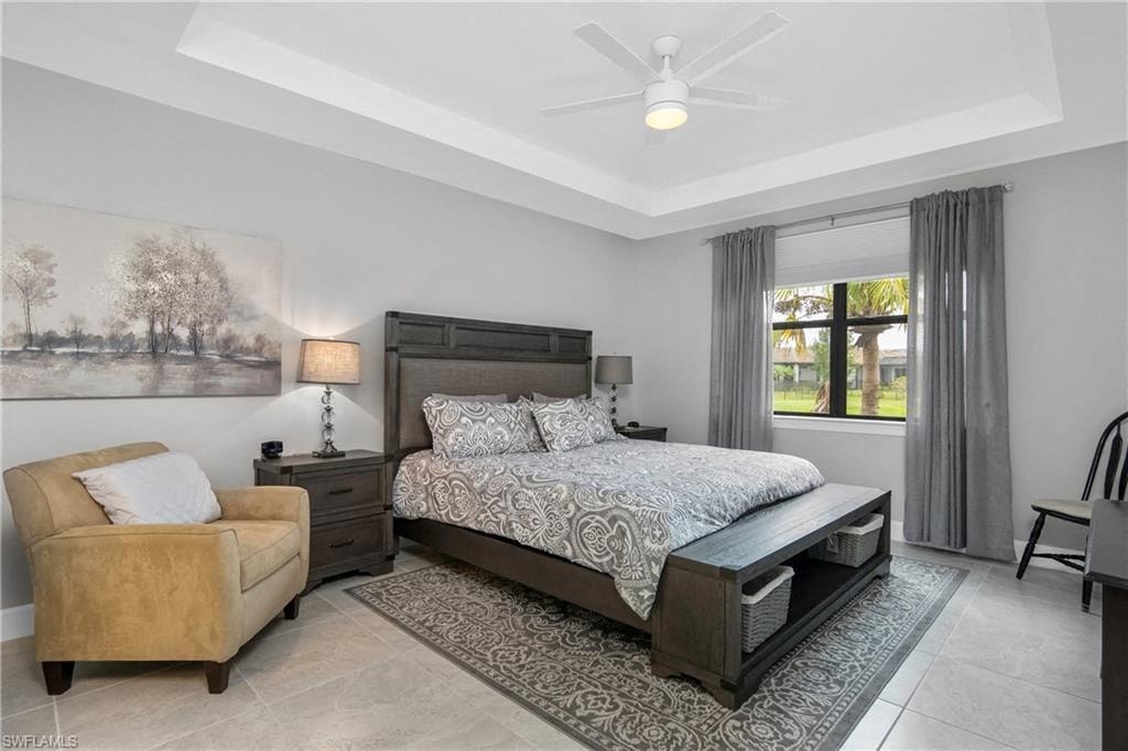 a bedroom with a bed and a chair and a ceiling fan