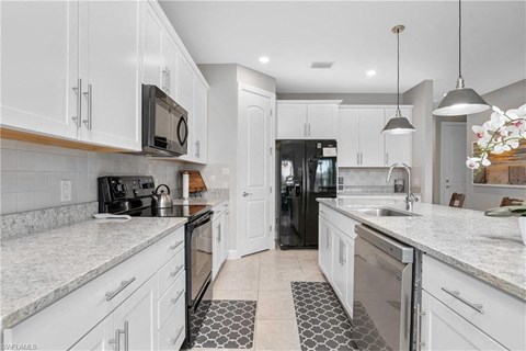 a large kitchen with white cabinets and a sink