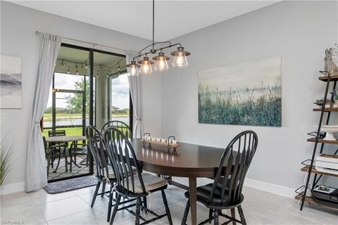a dining room with a table and chairs and a painting on the wall