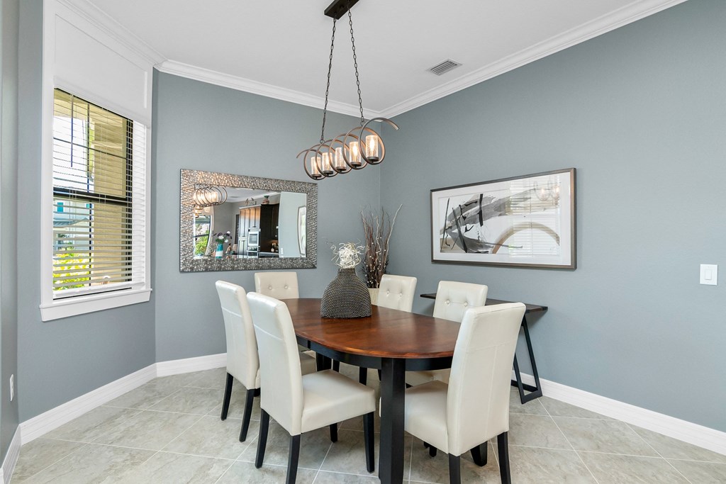 a dining room with a wooden table and white chairs