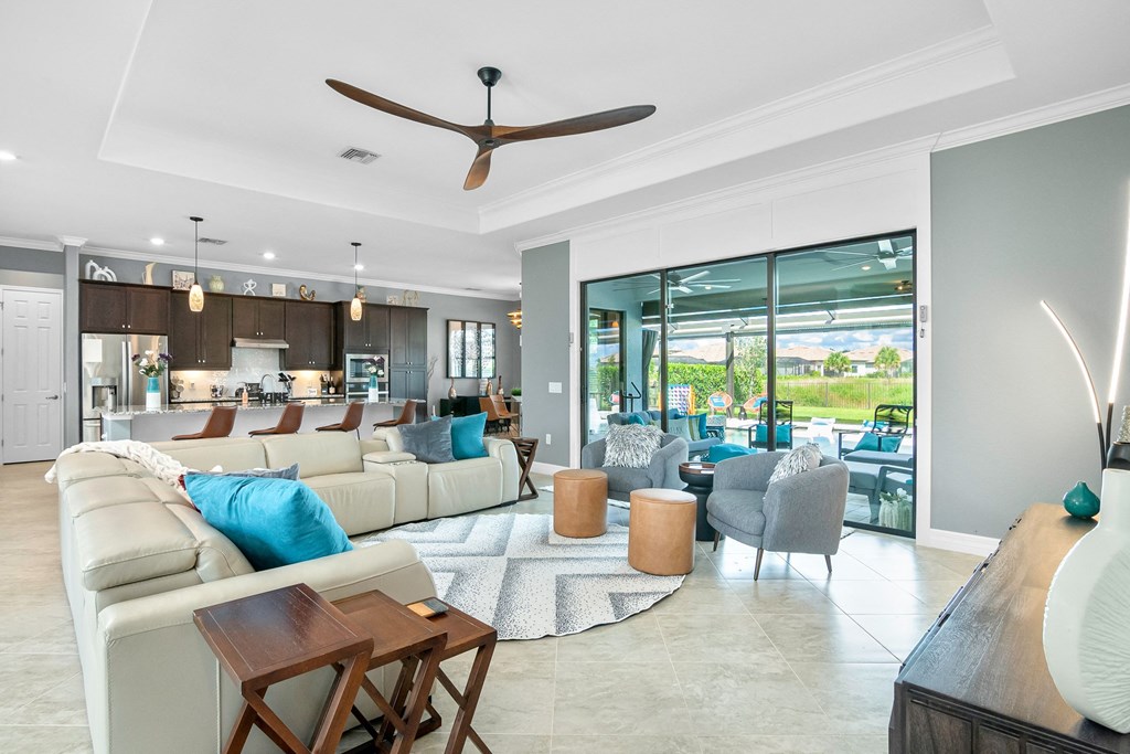 a living room with couches and chairs and a kitchen