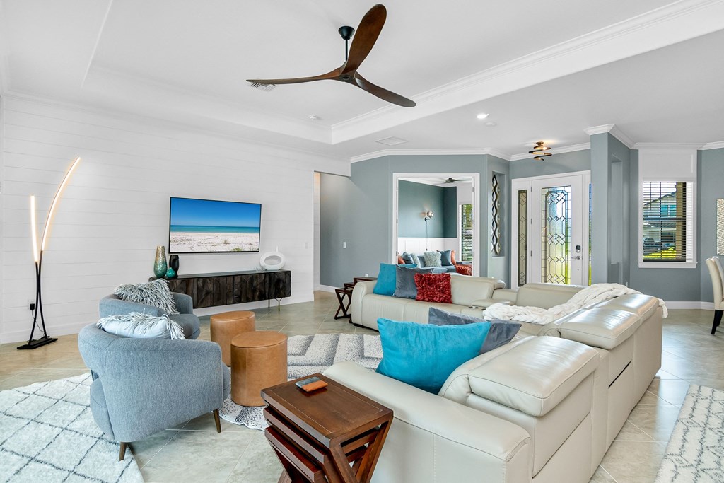 a living room with couches and chairs and a ceiling fan