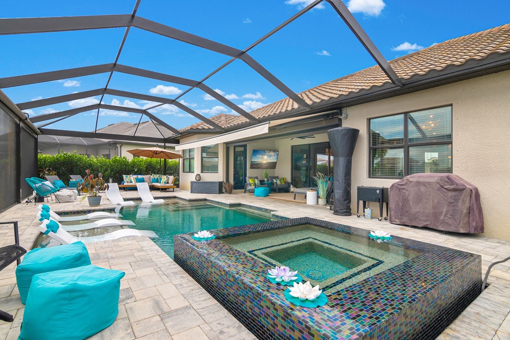 a backyard with a pool and patio furniture and a glass roof