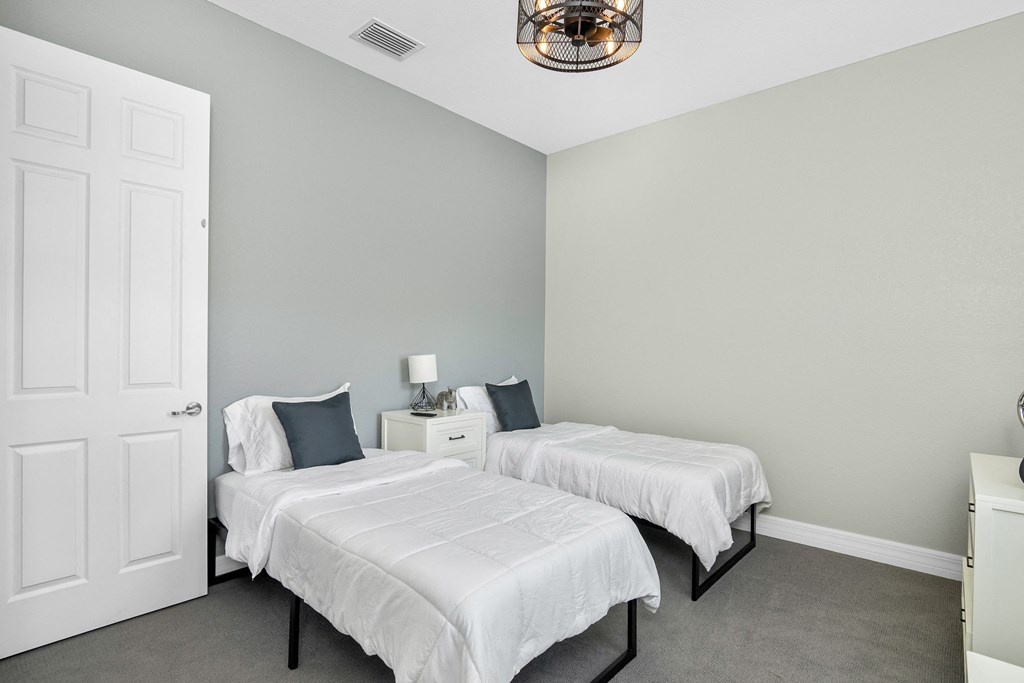 two beds in a bedroom with a closet and a door