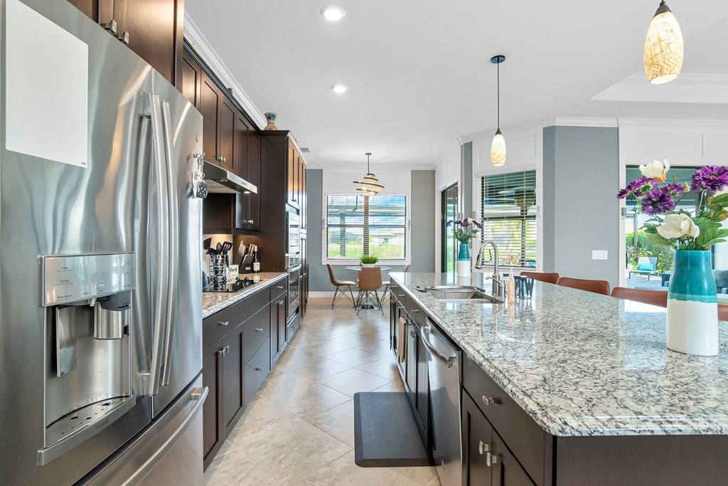 a large kitchen with stainless steel appliances and marble counter tops