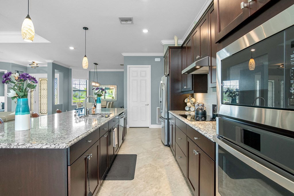 a large kitchen with stainless steel appliances and marble counter tops
