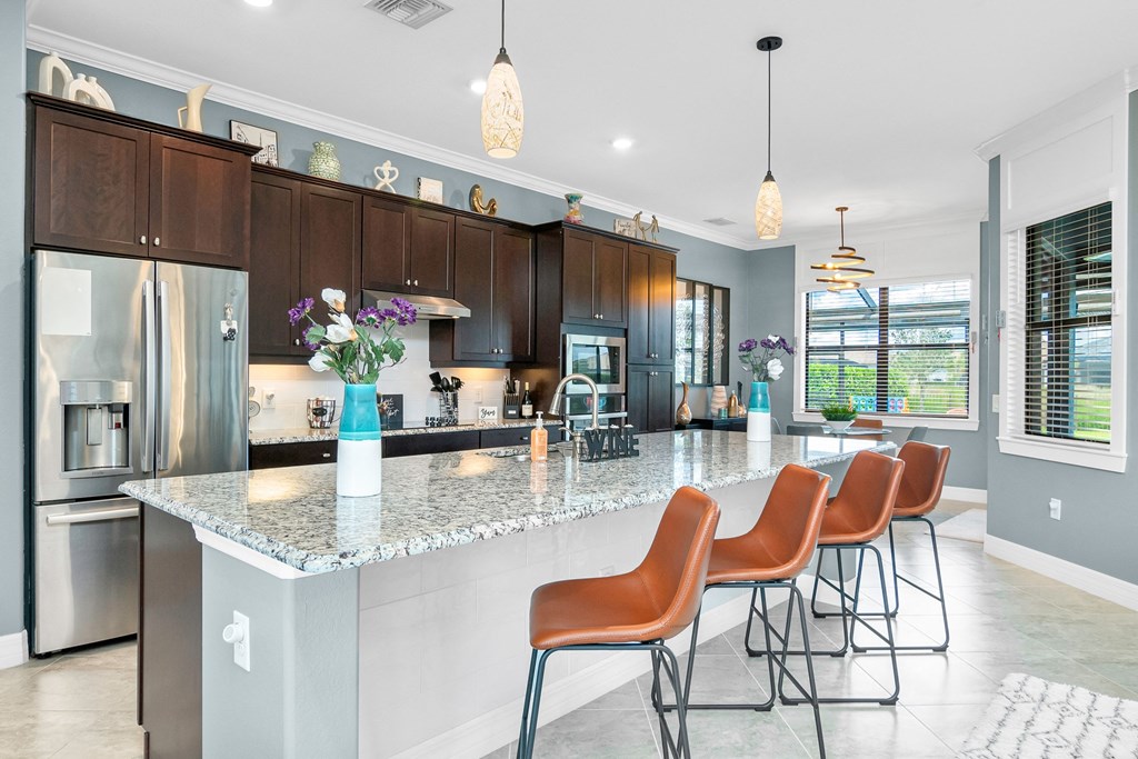 a modern kitchen with a large island with bar stools