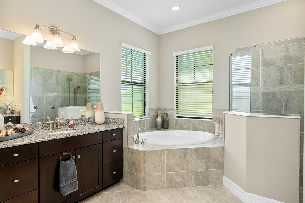 a bathroom with a tub and a sink and a mirror