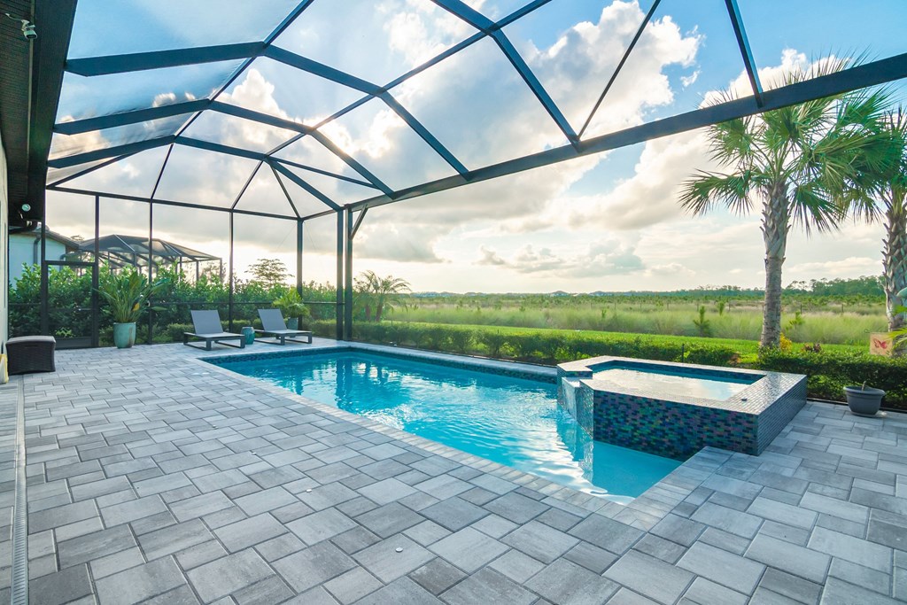 a patio with a pool and a hot tub under a glass roof