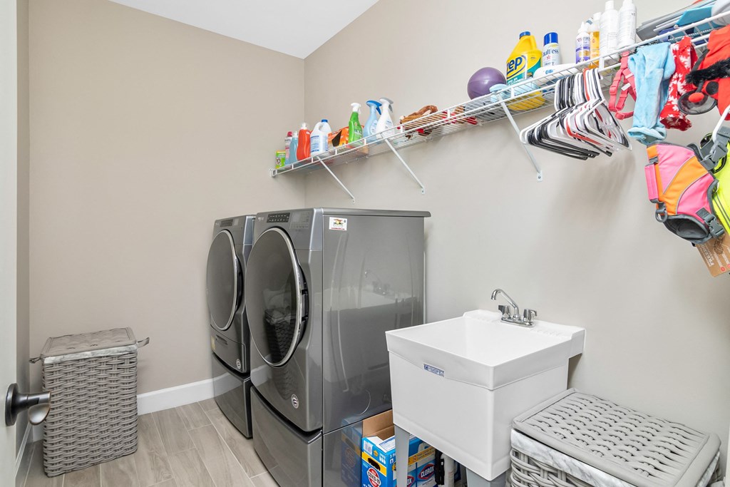 a laundry room with a washing machine and a sink and a dryer