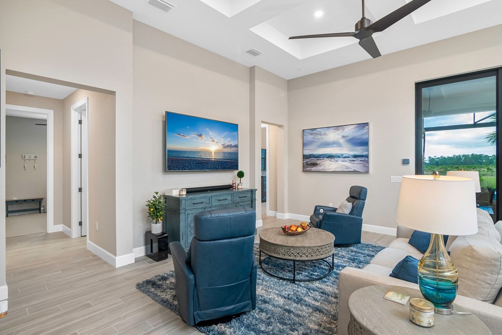 a living room with a couch and chairs and a ceiling fan
