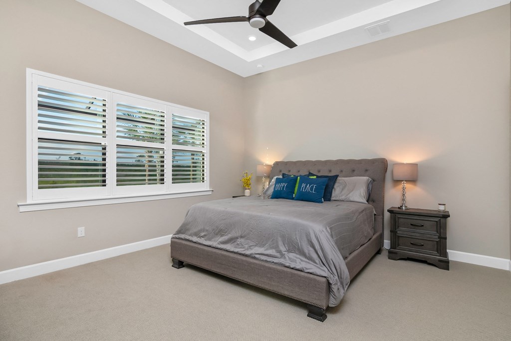 a bedroom with a bed and a ceiling fan