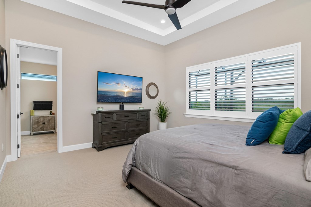 the master bedroom has a large bed and a tv