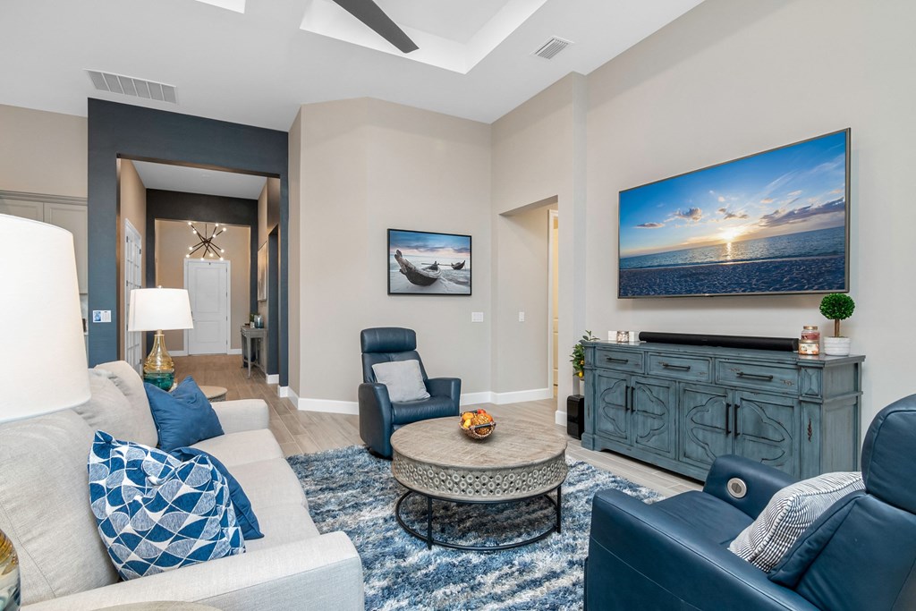 a living room with blue furniture and a tv on the wall