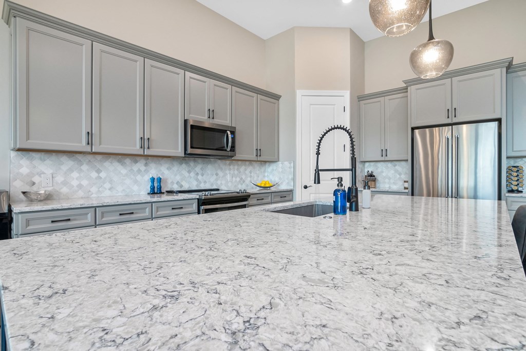 an open kitchen with a marble counter top