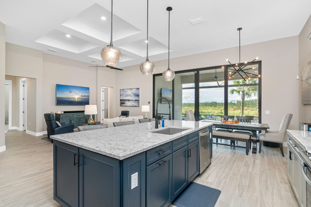 a kitchen with a large island and a living room with a table and chairs