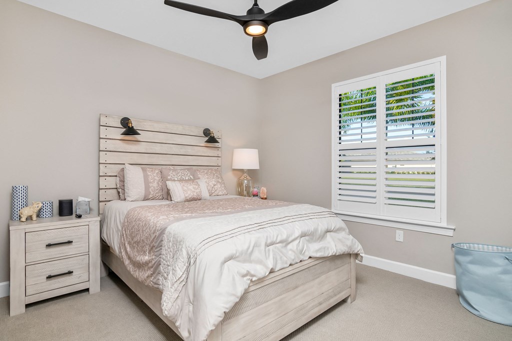 a bedroom with a bed and a ceiling fan