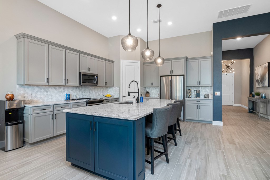 a large kitchen with blue cabinets and a marble counter top