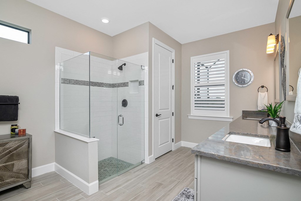 a bathroom with a shower and a sink and a mirror