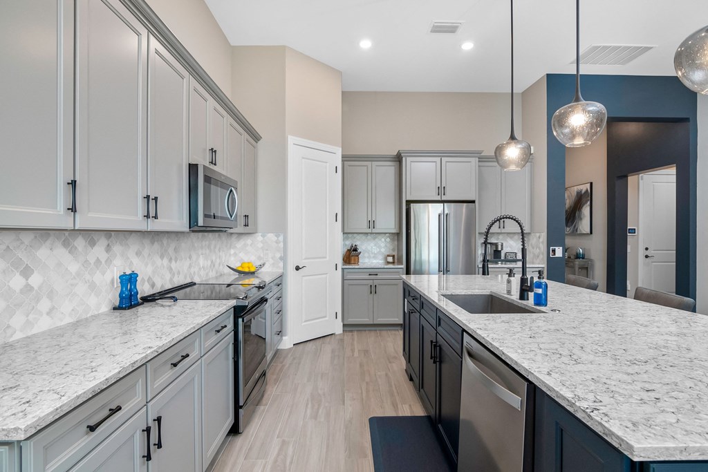 a large kitchen with marble counter tops and white cabinets