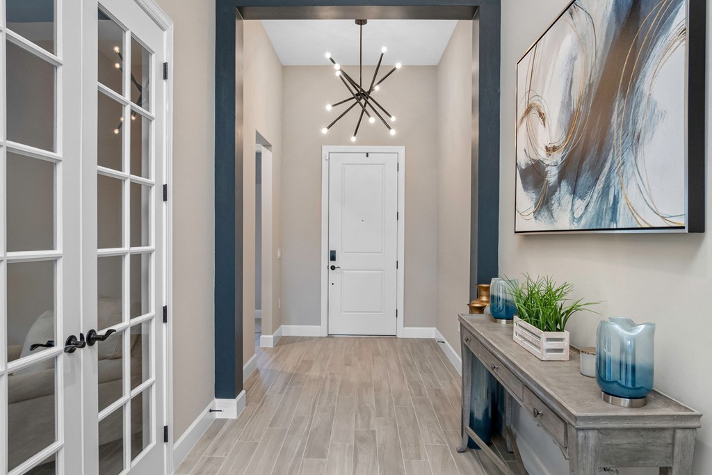 the foyer of a new home with a chandelier and a white door
