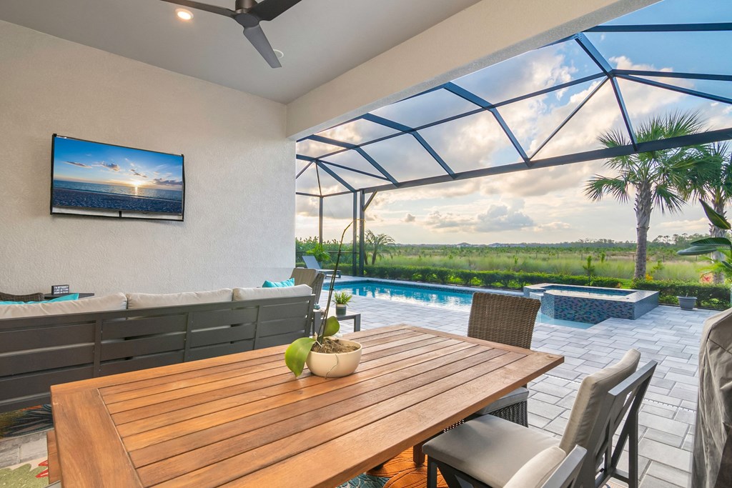 a patio with a table and chairs and a swimming pool