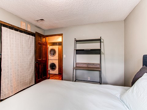 a bedroom with a bed and a closet and a laundry room