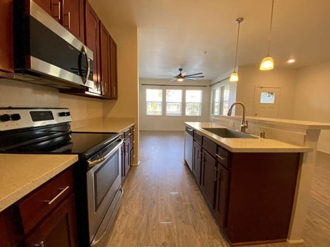 A kitchen with dark wood cabinets and a white countertop.