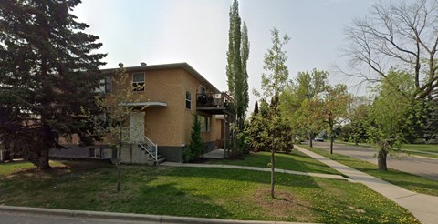 an apartment building on the corner of a sidewalk