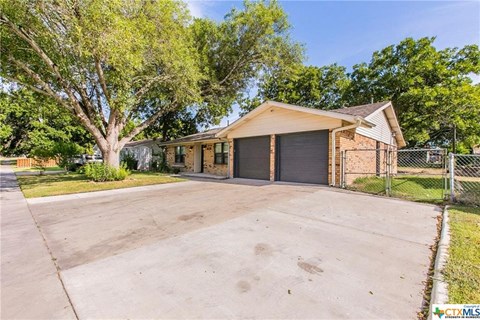 a large driveway in front of a house with a garage door