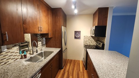 a kitchen with granite counter tops and wooden cabinets