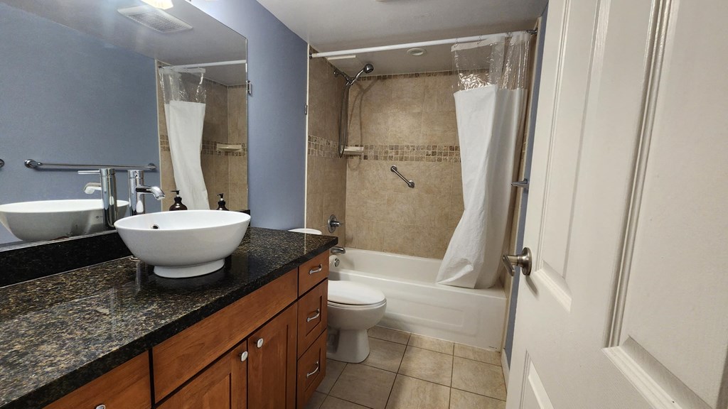 a bathroom with a sink and a shower and a toilet