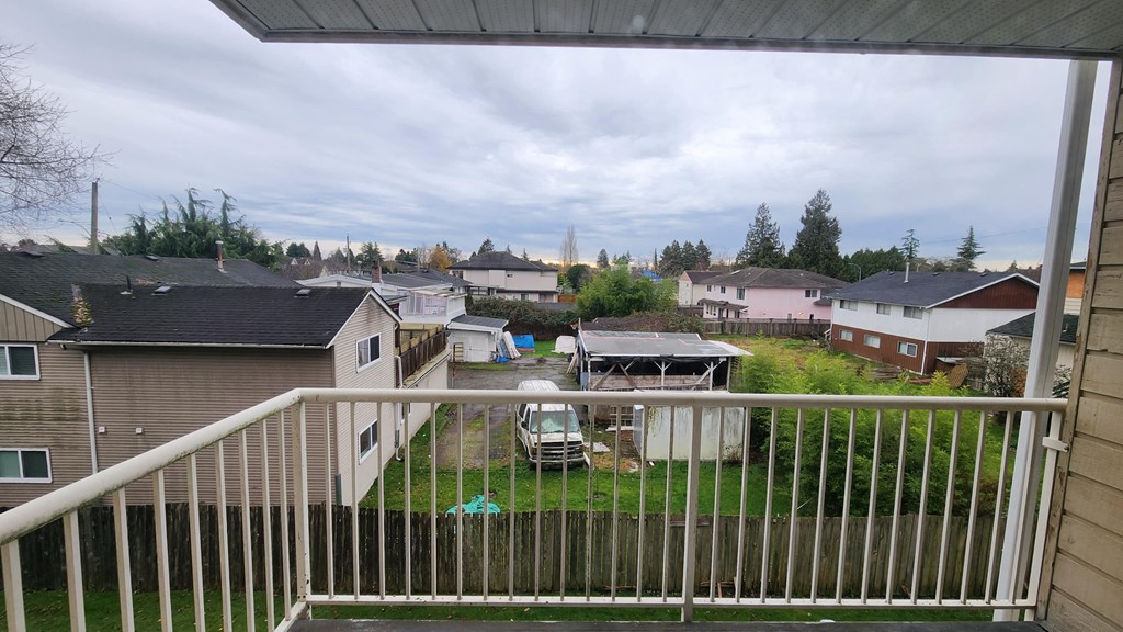 a view of a yard from a balcony with a fence