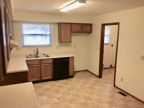 A kitchen with brown cabinets and a checkered floor.