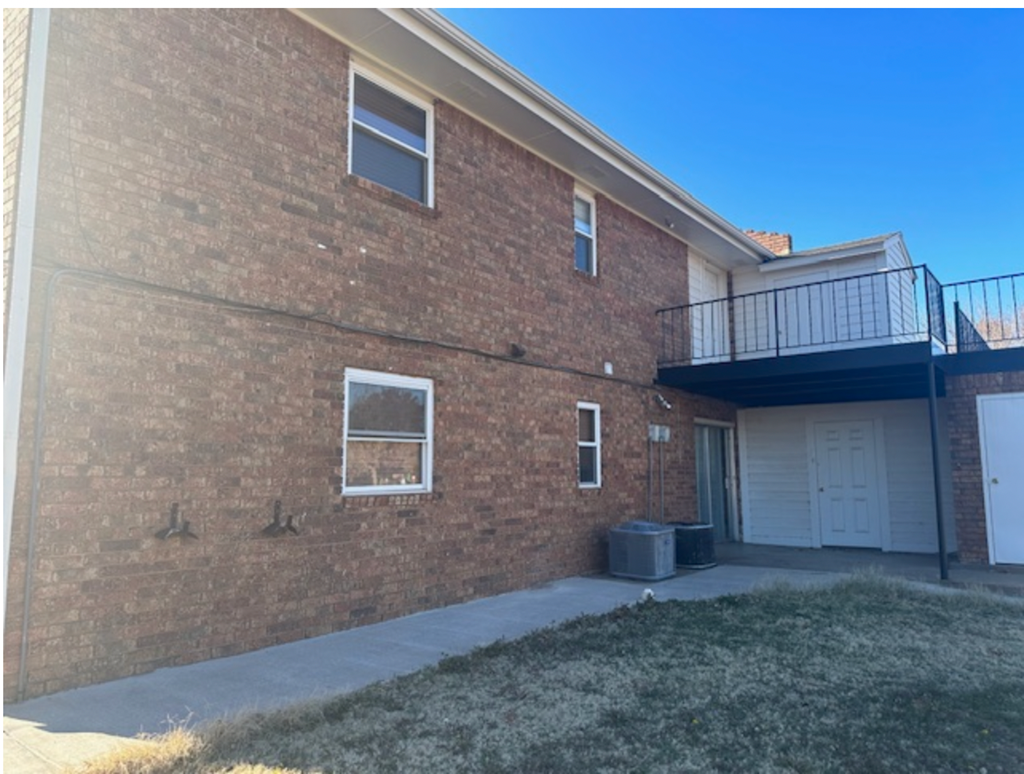 a brick building with a balcony and a sidewalk