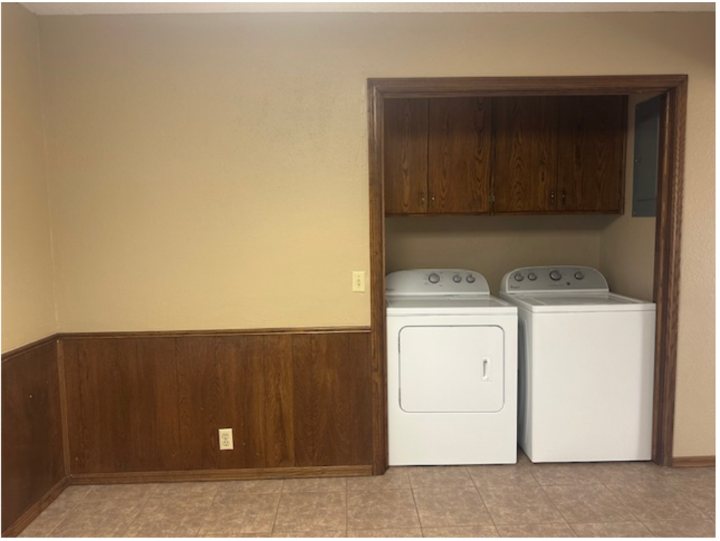 an empty laundry room with two washer and dryers in it