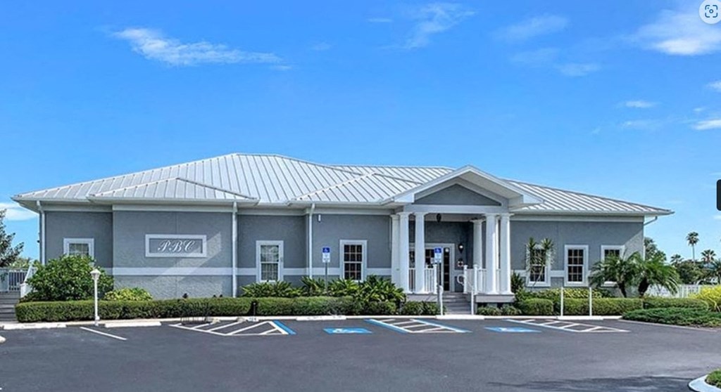 the front of a building with a parking lot in front of it