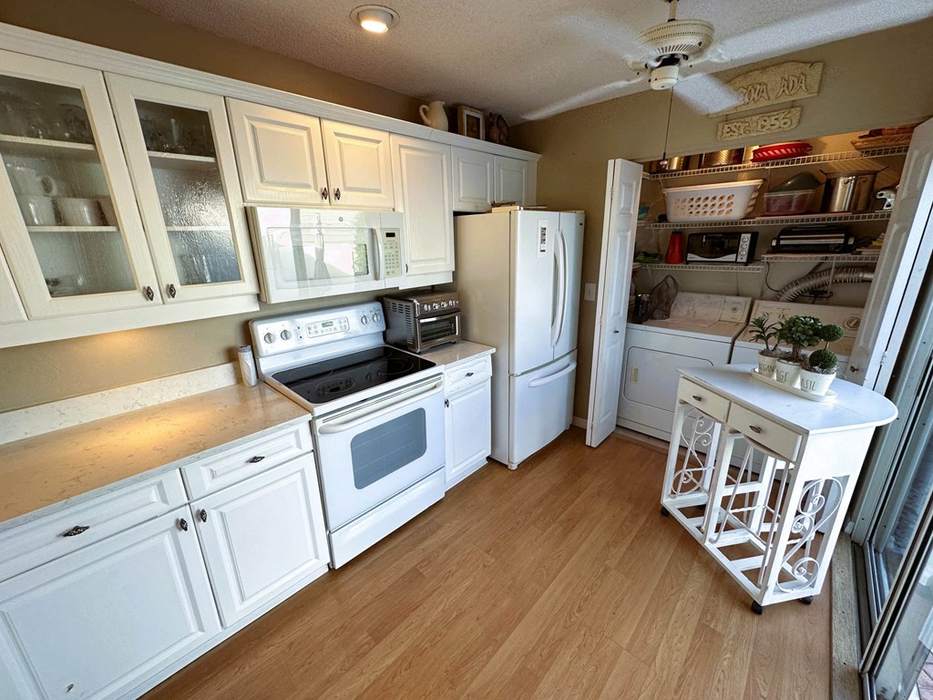 a kitchen with white cabinets and a stove and a refrigerator