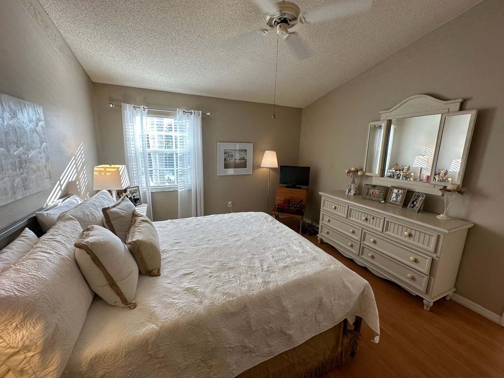 a bedroom with a bed and a dresser and a window