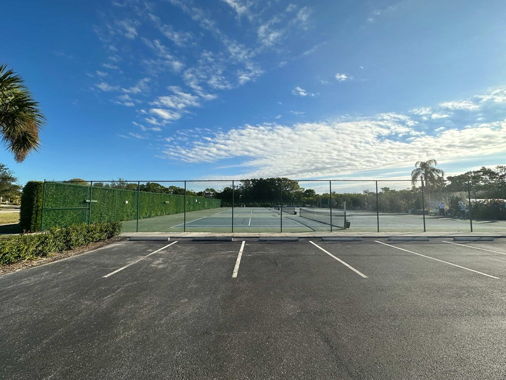 a tennis court in a parking lot with a fence