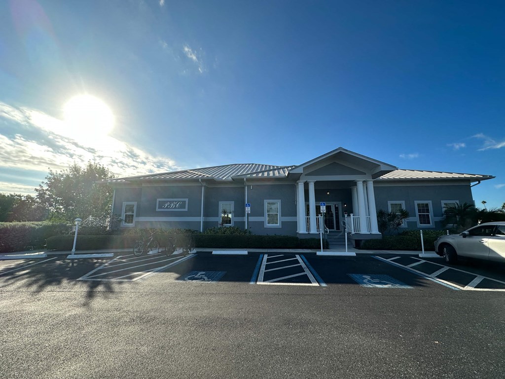 a building with a parking lot and the sun in the sky
