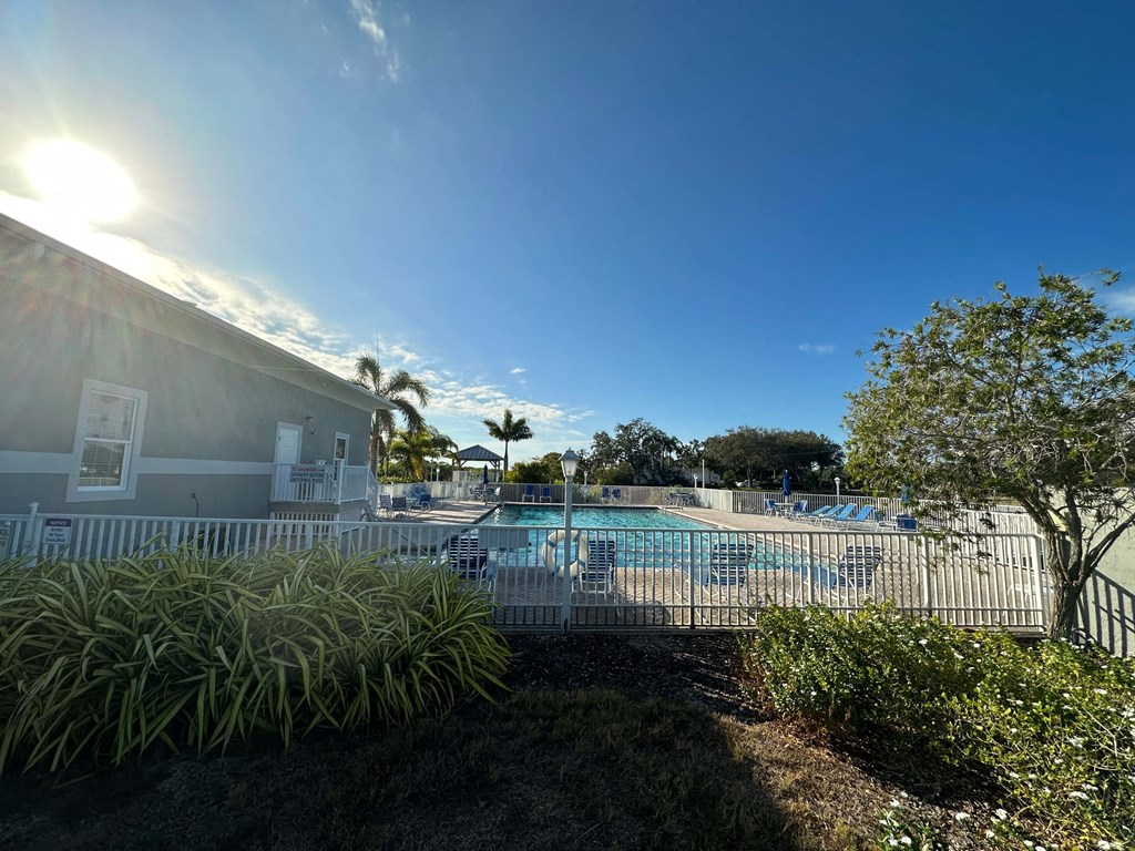 a resort style pool is next to a building with palm trees