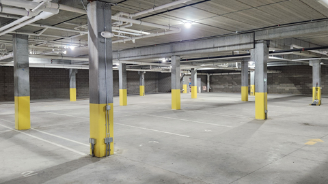 a parking garage with yellow poles in the floor