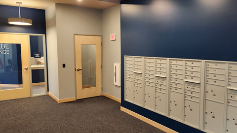 a locker room with a row of lockers and a door to a bathroom