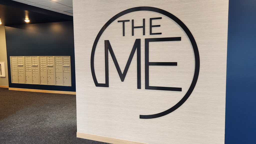 the me logo on a wall in a room with a calendar