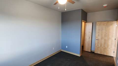 an empty room with a blue wall and a wooden door