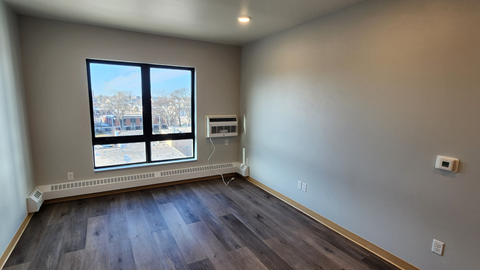 a living room with wood floors and a large window