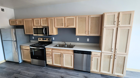 a kitchen with wooden cabinets and stainless steel appliances