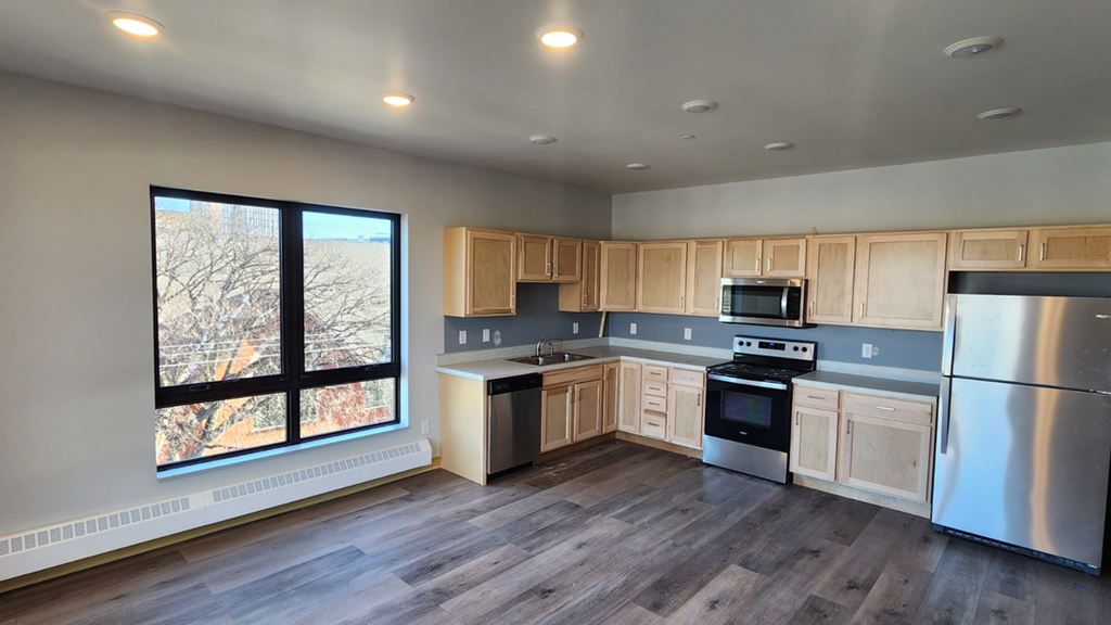 a kitchen with wooden cabinets and stainless steel appliances