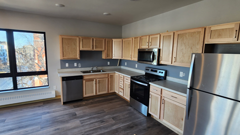 a kitchen with wooden cabinets and stainless steel appliances